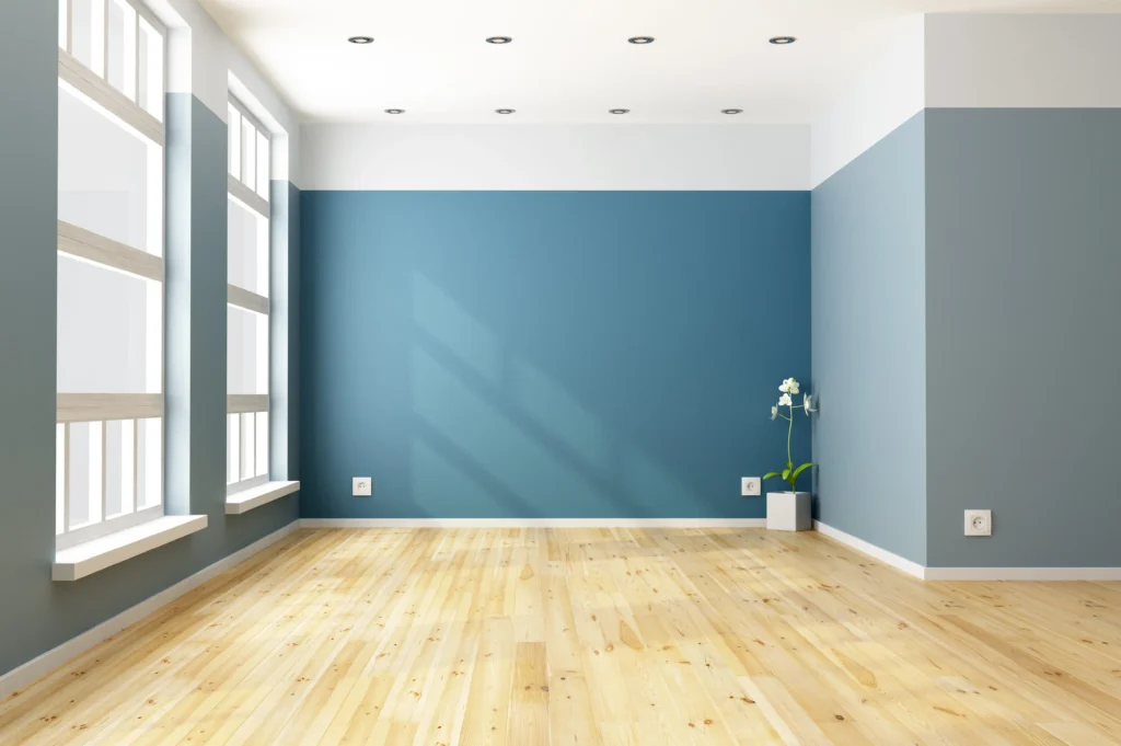 Painter calculating how much paint is needed for a 12x12 ft room while painting an interior wall